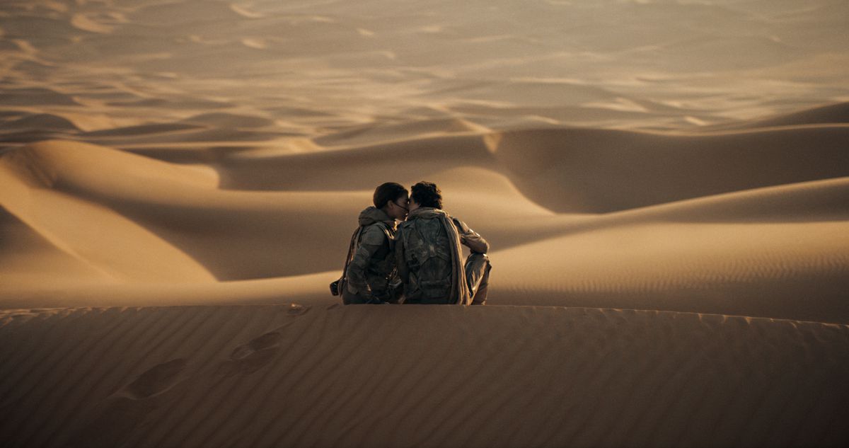 Paul de Timothée Chalamet et Chani de Zendaya s'embrassent au sommet d'une dune de sable dans Dune : Deuxième partie.