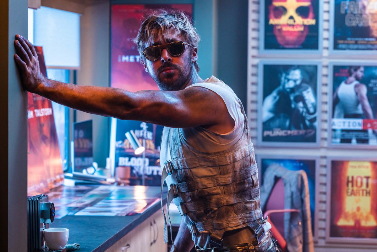 Dans une scène de The Fall Guy, le cascadeur Colt Seavers (Ryan Gosling, portant des lunettes de soleil, un gilet sans manches sale et un air renfrogné) s'appuie un bras contre un mur dans une pièce bordée d'affiches de films de couleur néon.
