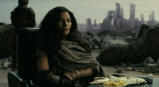Moldaver in the Fallout TV series, a woman with long black hair sitting in a chair in front of an open wall.