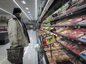 Un homme fait ses courses au rayon viande