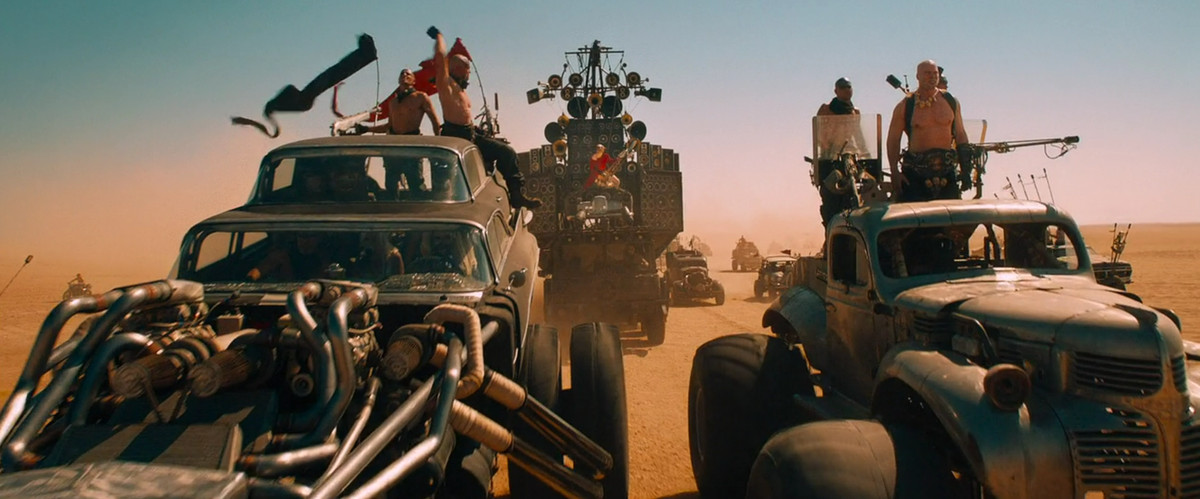 Le Doof Wagon du Doof Warrior flanqué de deux des autres véhicules d'Immortan Joe dans Mad Max: Fury Road