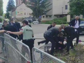 Cette image tirée d'une séquence vidéo montre des agents de sécurité transportant le Premier ministre slovaque Robert Fico (au centre) vers un véhicule après qu'il ait été abattu à Handlova le 15 mai 2024.