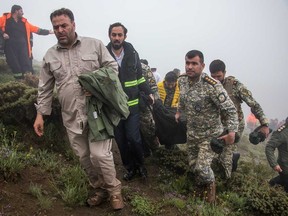 Des membres de l'équipe de secours récupèrent le corps d'une victime sur le site du crash d'un hélicoptère transportant le président iranien Ebrahim Raisi à Varzaghan, dans le nord-ouest de l'Iran, le 20 mai 2024.