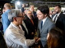 Le directeur général de Honda, Toshihiro Mibe, serre la main du premier ministre Justin Trudeau lors d'un événement visant à annoncer la construction d'une nouvelle usine d'assemblage de batteries et d'automobiles pour véhicules électriques à Alliston, en Ontario, le 25 avril 2024. 