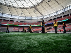 Des équipes travaillent sur le gazon de BC Place lors d'une mise à jour sur la Coupe du Monde de la FIFA 2026 à Vancouver, le mardi 30 avril 2024.