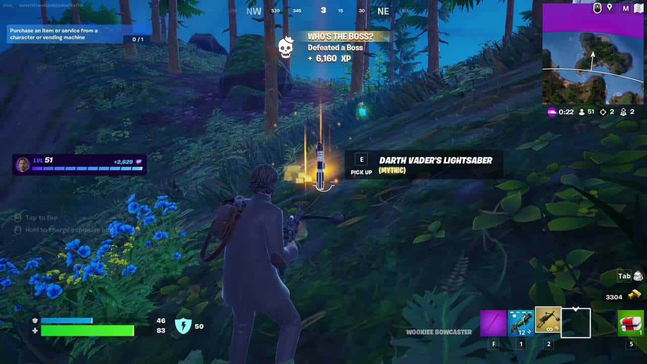 Les sabres laser de retour dans Fortnite : un joueur sur une colline herbeuse regardant le sabre laser de Dark Vador posé au sol devant lui dans Fortnite.