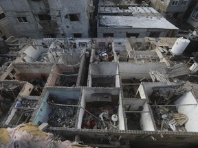 Des Palestiniens regardent les destructions après une frappe israélienne contre un immeuble résidentiel à Rafah, dans la bande de Gaza, le mardi 7 mai 2024.
