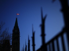 Près de 60 pour cent des Canadiens estiment que la liberté d'expression est menacée, et près d'un sur quatre considère cette menace comme sérieuse, suggère un nouveau sondage.  Le drapeau du Canada illumine la lumière du matin sur la Tour de la Paix sur la Colline du Parlement à Ottawa, le mardi 16 avril 2024.