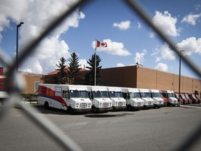 Des véhicules de livraison sont vus à l'usine principale de Postes Canada à Calgary, en Alberta, le samedi 9 mai 2020.