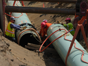 Des travailleurs posent des tuyaux pendant la construction de l'agrandissement du pipeline Trans Mountain, maintenant terminé, sur des terres agricoles à Abbotsford, en Colombie-Britannique, le mercredi 3 mai 2023.