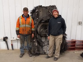 Barry Sawchuk (à gauche) et Samantha Lawler, professeure agrégée d'astronomie à l'Université de Regina, posent près d'un débris spatial trouvé dans sa ferme en février.