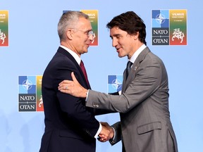 Jens Stoltenberg et Justin Trudeau se serrent la main.