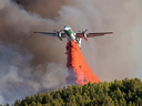 Un avion-citerne Convair Dash 8, utilisé pour la gestion des incendies de forêt en Saskatchewan, largue du matériel de suppression le 23 avril 2024.