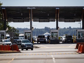 Un agent de l'Agence des services frontaliers du Canada se profile alors que des automobilistes entrent au Canada au poste frontalier de Douglas-Peace Arch, à Surrey, en Colombie-Britannique, le lundi 9 août 2021.