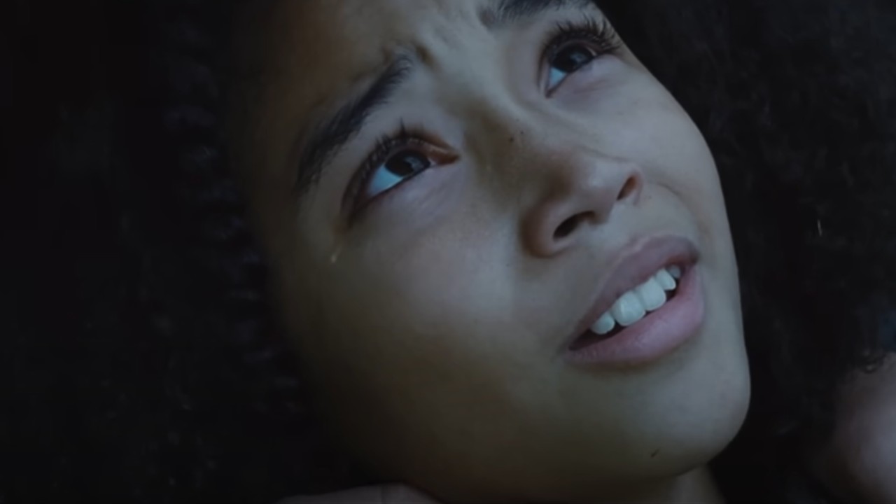 Une larme coule sur le visage de Rue lors d'un gros plan pendant The Hunger Games.