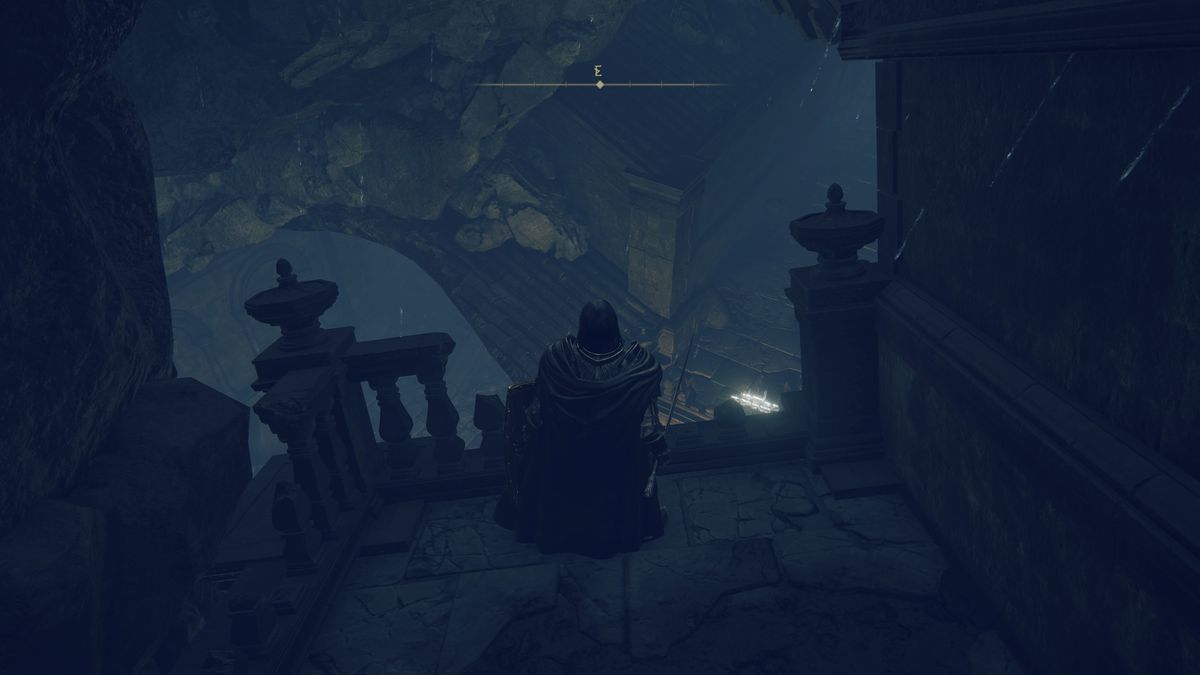 Un guerrier terni se tient sur un rebord regardant la zone souterraine des ruines de Moorth dans une capture d'écran d'Elden Ring : Shadow of the Erdtree.