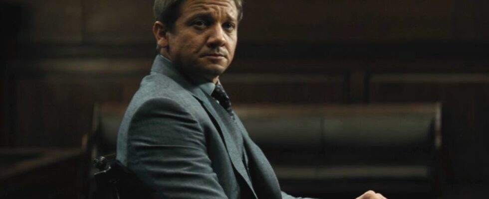 Jeremy Renner sits in a hearing room with a rather upset look in Mission Impossible: Rogue Nation.