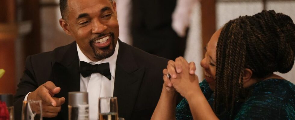 Jason George as Ben Warren laughs with Chandra Wilson as Miranda Bailey as they sit at a table during a firefighters banquet on the May 18, 2024, episode of Station 19,