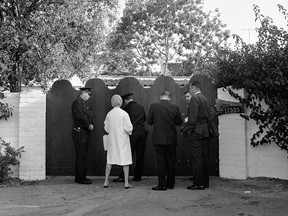 Sur cette photo d'archive du 5 août 1962, des policiers et des journalistes se tiennent devant la porte d'entrée de la maison de Marilyn Monroe après qu'elle ait été retrouvée morte dans sa chambre.  La maison à un étage de style espagnol se trouve dans le quartier Brentwood de Los Angeles.