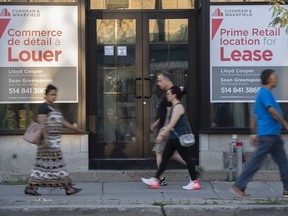 Des gens passent devant des panneaux bilingues indiquant un espace commercial à louer dans la ville de Westmount, sur l'île de Montréal, le vendredi 5 août 2022.