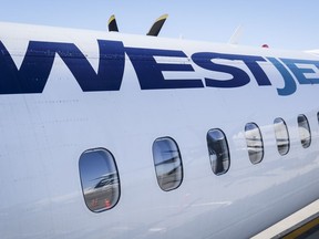 Un avion de WestJet attend à une porte de l'aéroport international de Calgary, à Calgary, en Alberta, le mercredi 31 août 2022. WestJet annule des vols en prévision d'une éventuelle grève de son syndicat de mécaniciens.