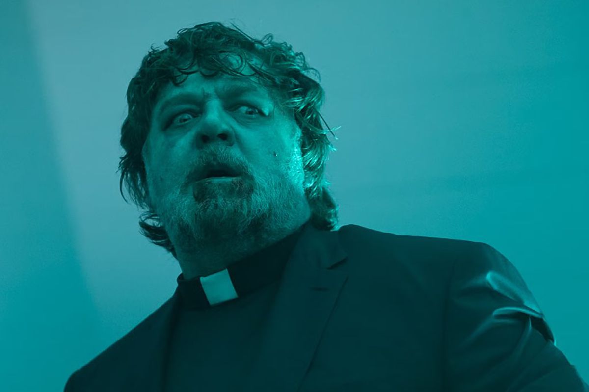 Russell Crowe déguisé en prêtre avec de la bile séchée et du sang couvrant sa barbe dans L'Exorcisme.