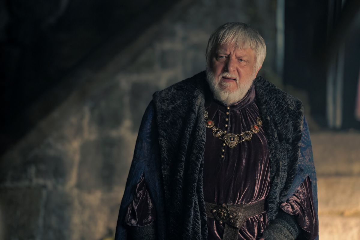 Ser Simon Strong (Sir Simon Beale) semble perplexe dans une scène se déroulant à Harrenhal dans l'épisode 4 de la saison 2 de House of the Dragon.