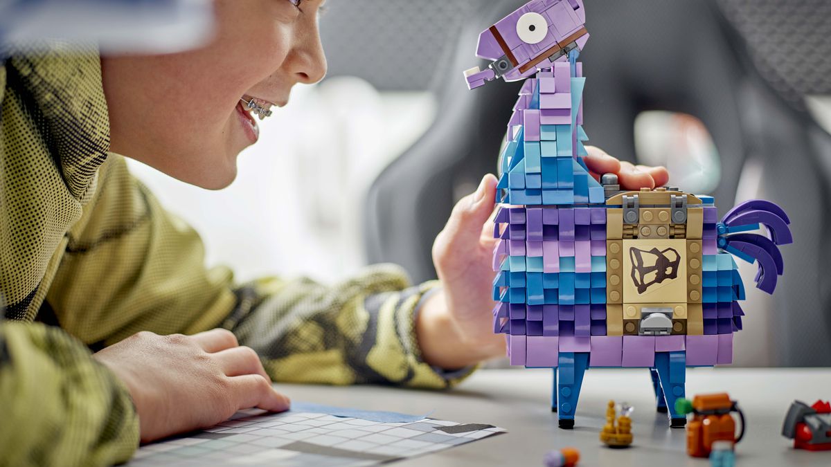 Un lama de Fortnite sous forme de Lego. Un enfant le regarde en souriant.