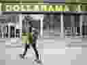 Une personne passe devant un magasin Dollarama Inc. à Montréal.