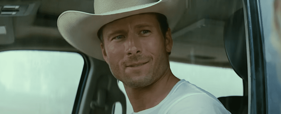 Glen Powell wearing a cowboy hat and driving a car in Twisters