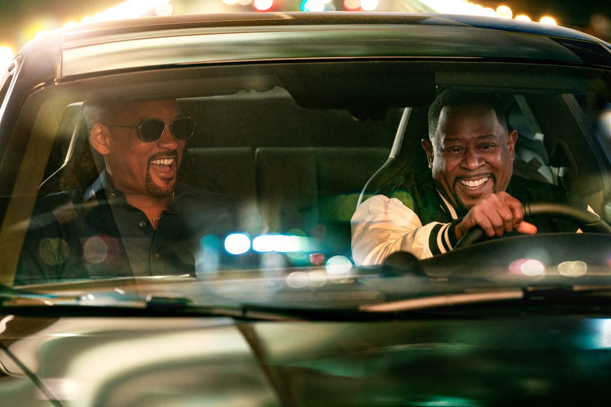 Will Smith est assis sur le siège passager tandis que Martin Lawrence conduit tandis que les deux rient dans une scène de Bad Boys : Ride or Die.