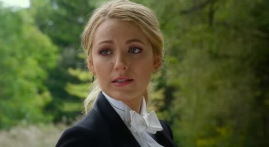 Blake Lively in A Simple Favor wearing a tux and looking over her shoulder.