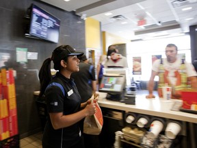 Emilia D'Cruze, 17 ans, apporte un repas à un client alors qu'elle prépare des commandes chez McDonald's à Toronto, en 2012.