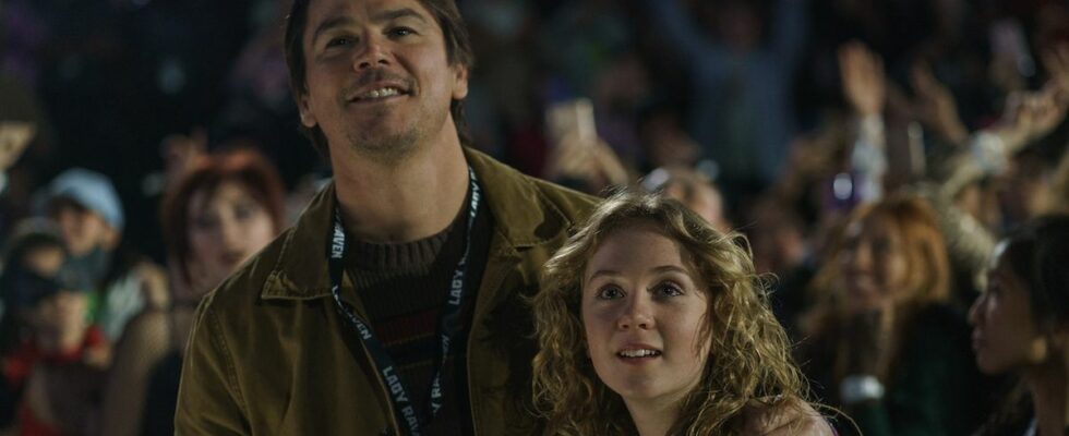 Cooper with his arm around daughter Riley in a concert crowd in M. Night Shyamalan