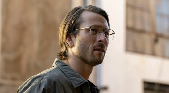 Glen Powell wearing glasses and collared shirt with long-ish hair in Netflix