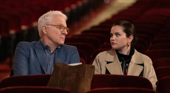 Charles and Mabel sitting in theater seats eyeing each other suspiciously in Only Murders in the Building Season 3