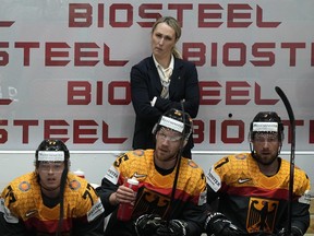L'entraîneur adjoint de l'Allemagne, Jessica Campbell, se tient derrière les joueurs sur le banc allemand lors du match du groupe A du Championnat du monde de hockey entre la France et l'Allemagne à Helsinki, en Finlande, le lundi 16 mai 2022.
