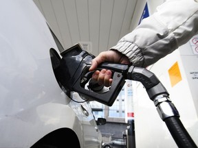 Une femme fait le plein d'essence dans une station-service à Mississauga, en Ontario, le mardi 13 février 2024.