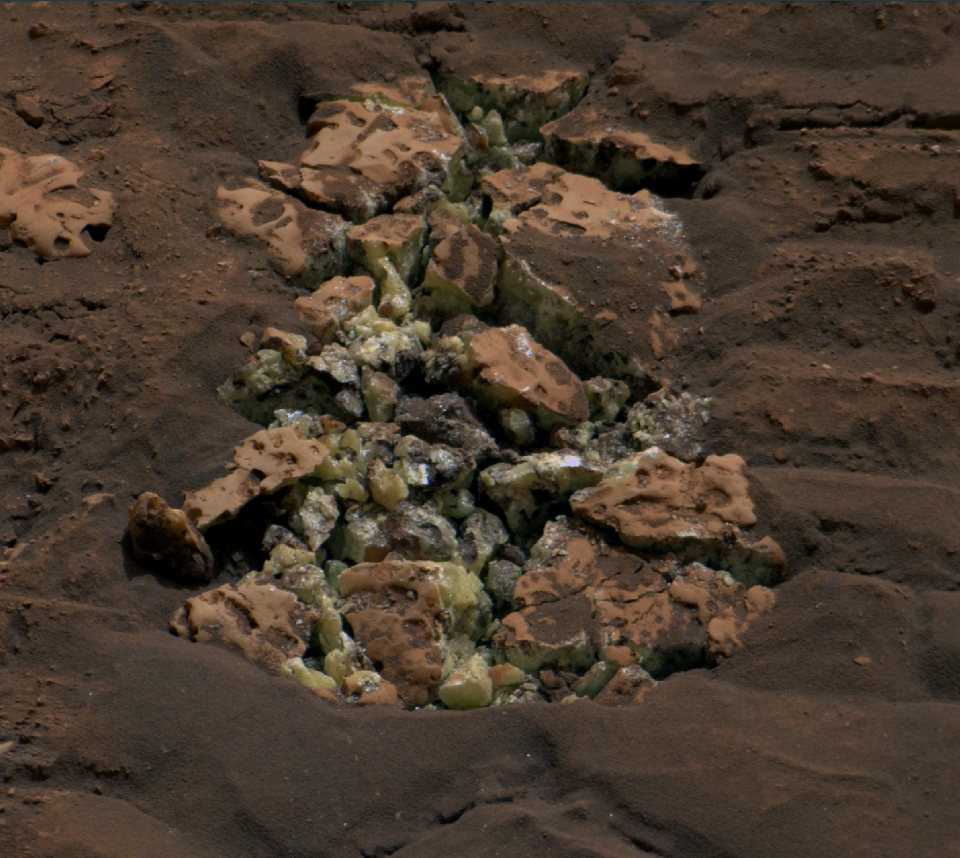 Un rocher écrasé et fissuré par le rover Curiosity révélant des cristaux de soufre jaune