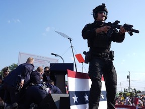 L'ancien président Donald Trump, candidat républicain à la présidentielle, est entouré d'agents des services secrets américains sur scène lors d'un rassemblement de campagne, le samedi 13 juillet 2024, à Butler, en Pennsylvanie.