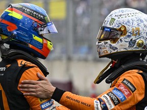 Le pilote McLaren Lando Norris de Grande-Bretagne, à droite, serre la main du pilote McLaren Oscar Piastri d'Australie après avoir signé la pole position lors de la séance de qualification avant la course automobile du Grand Prix de Hongrie de Formule 1 de dimanche, sur le circuit Hungaroring à Mogyorod, près de Budapest, en Hongrie, samedi 20 juillet 2024.