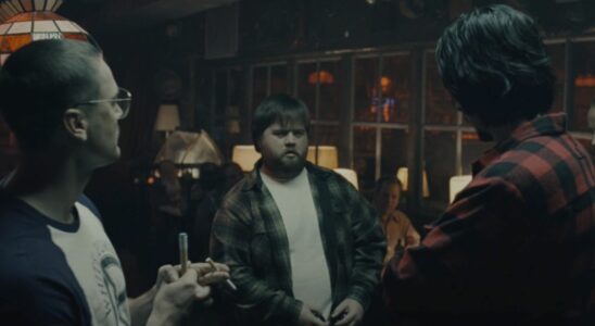 Paul Walter Hauser stands in the middle of a group of guys playing pool in BlacKkKlansman.