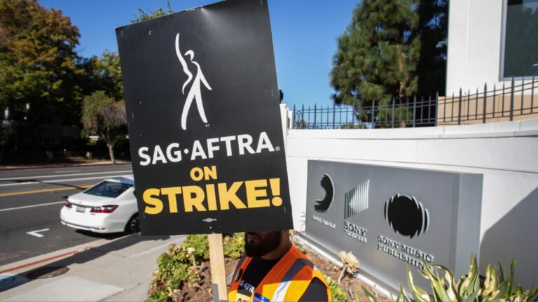 LOS ANGELES, CALIFORNIA - OCTOBER 11: A worker holding a picket sign stands in front of the Sony Pictures Studio during a SAG-AFTRA picket line on October 11, 2023 in Culver City, California. The WGA (Writers Guild of America) has reached a deal with Hollywood studios after 146 days on strike, ending their strike at midnight on September 27. SAG-AFTRA has not reached a deal with the studios and has been on strike since July 14.