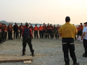 Les superviseurs de division du Nouveau-Brunswick et de l'Ontario donnent un briefing matinal aux pompiers forestiers du complexe Algar Lake près de Fort McMurray, en Alberta, sur une photo distribuée le samedi 20 juillet 2024.