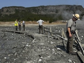 Sur cette photo publiée par le National Park Service des États-Unis, le personnel du parc évalue les dégâts causés aux promenades de Biscuit Basin après une explosion hydrothermale à Biscuit Basin dans le parc national de Yellowstone, Wyoming, le mardi 23 juillet 2024.