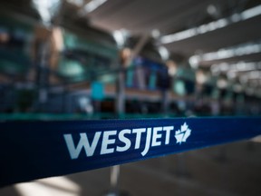Les voyageurs qui transitent par les aéroports se demandent s'ils pourront prendre leur vol WestJet pendant la longue fin de semaine de la fête du Canada. Un logo WestJet est visible dans la zone d'enregistrement des vols intérieurs de l'aéroport international de Vancouver, à Richmond, en Colombie-Britannique, le vendredi 19 mai 2023.