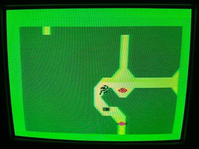 Une capture d'écran d'Advanced Dungeons & Dragons, montrant une petite silhouette en pixels noirs courant depuis deux taches roses à travers un donjon vert et jaune.