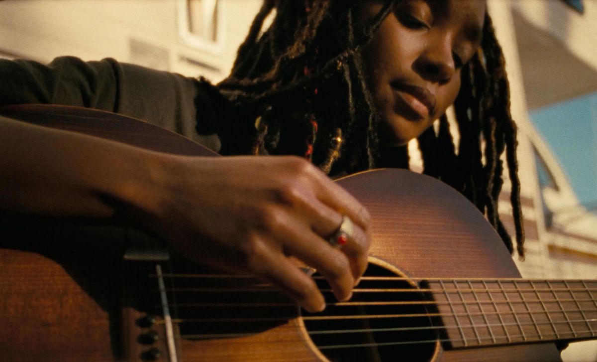 Gros plan d'une femme jouant de la guitare à Dandelion.