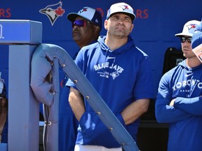 Joey Votto des Blue Jays de Toronto regarde depuis l'abri pendant l'entraînement de printemps.