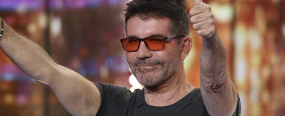 Simon Cowell in orange-tinted glasses giving the crowd two thumbs up on America